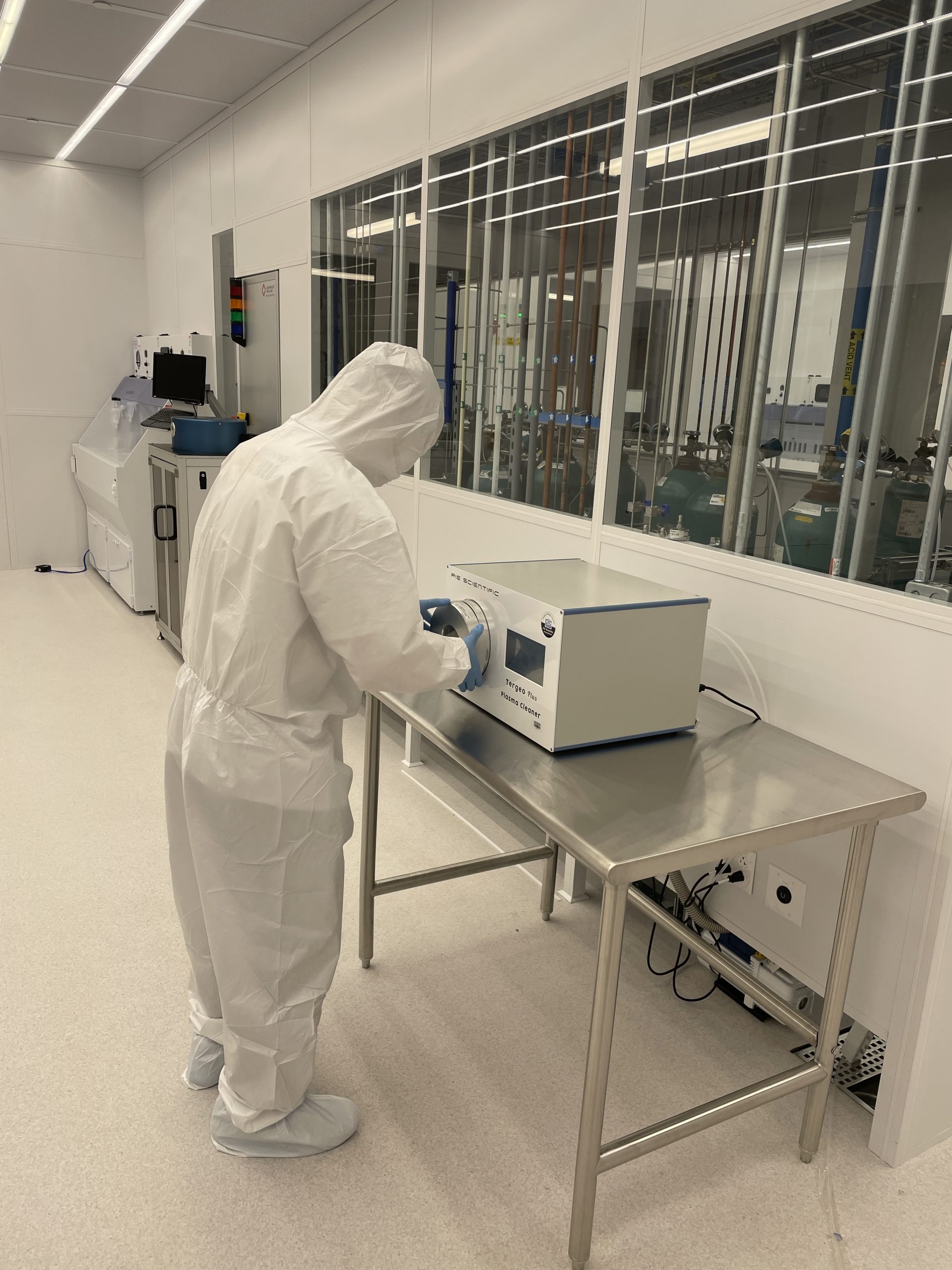 person working a plasma cleaner in cleanroom bay 1