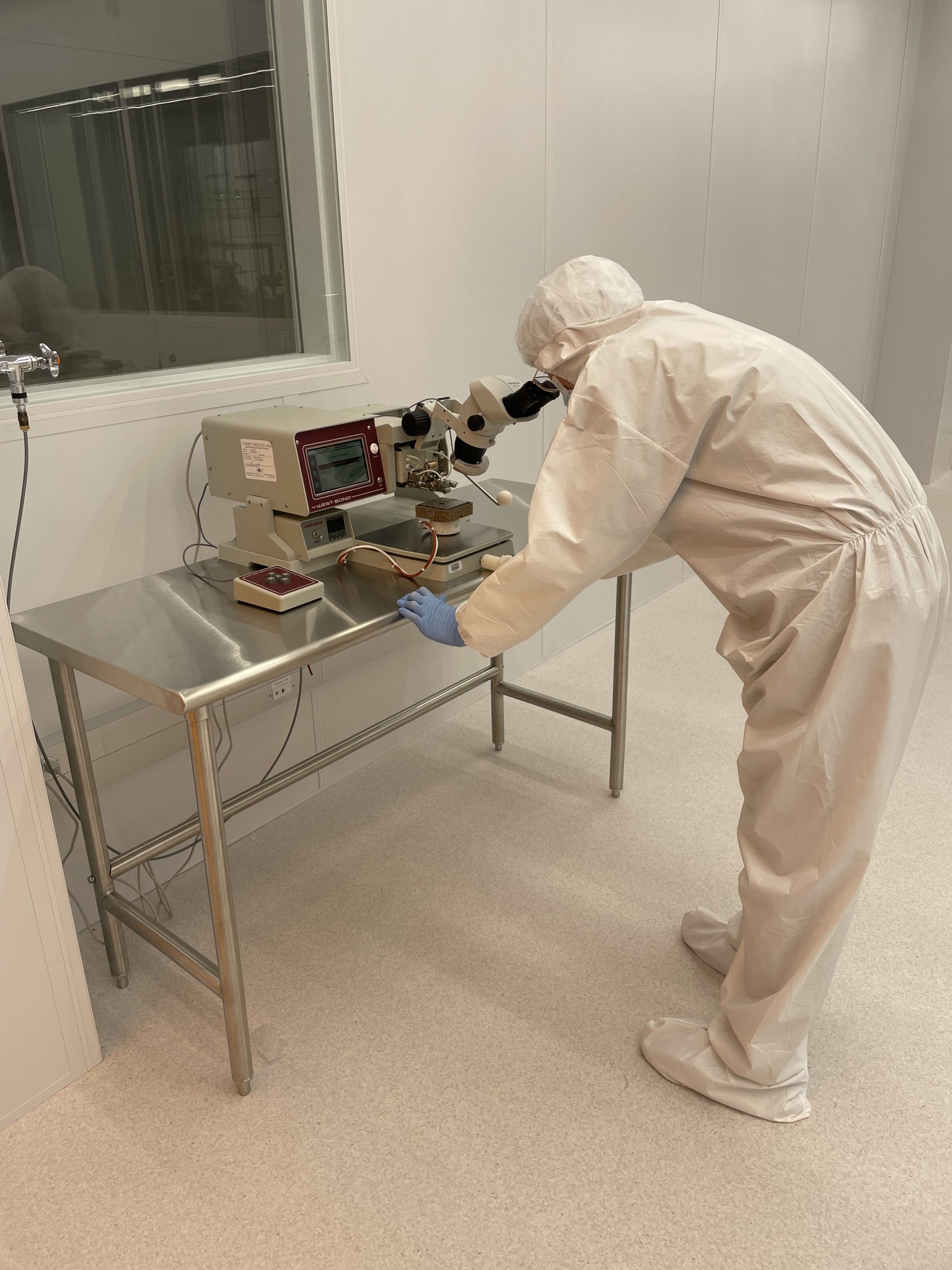 person working at wire bonder in cleanroom bay 2